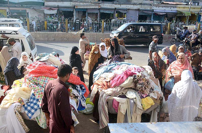 Women selecting used clothes at a roadside stall