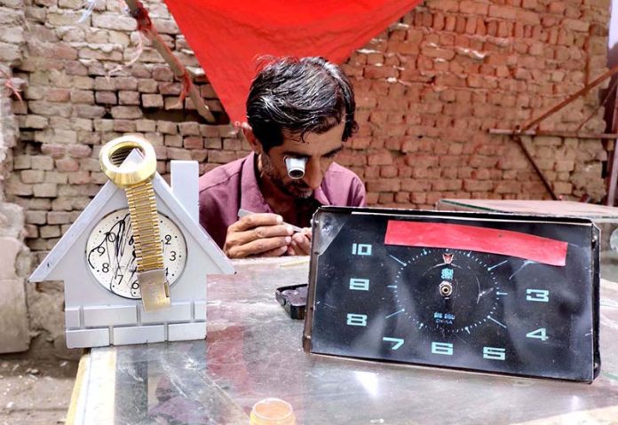 A worker repairing watch at his roadside setup near Jinnah Bagh