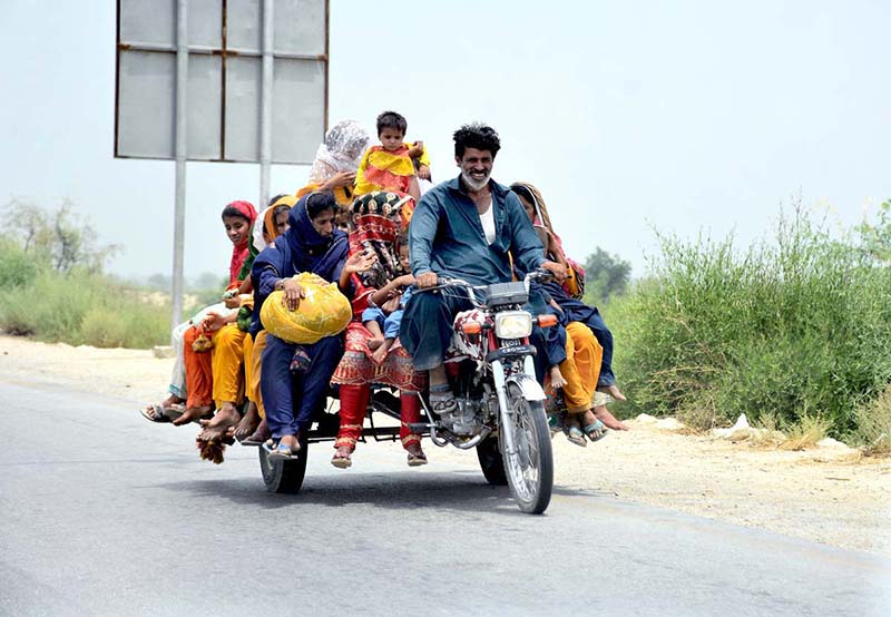 A gypsy family traveling on tricycle cart at Mohenjo-Daro Airport Road