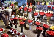 A vendor display and decorate a bouquet of flowers to attract customers