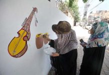 Students painting on the wall of GPO during city beautification campaign organized by DC Peshawar