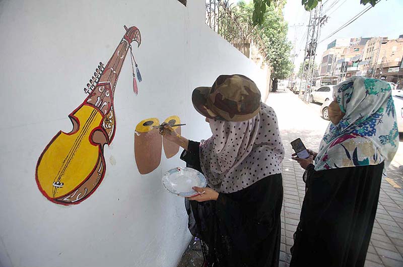 Students painting on the wall of GPO during city beautification campaign organized by DC Peshawar