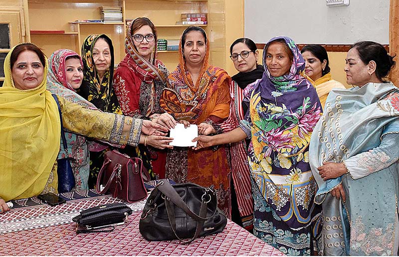 President Gomi Bai Ladies Club Fareeda Pechuho, General Secretary Sakina Gaad and members distributing money to a female worker in connection with International Labour Day