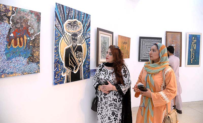 Visitors watching artworks during painting exhibition on Sufism in Al Hamar Hall