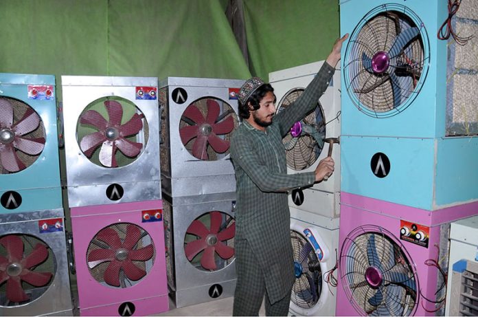 A worker preparing room coolers for costumers at his workplace in the Federal Capital
