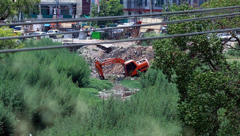 Heavy machinery being used to clean a nullah at Kuri Road