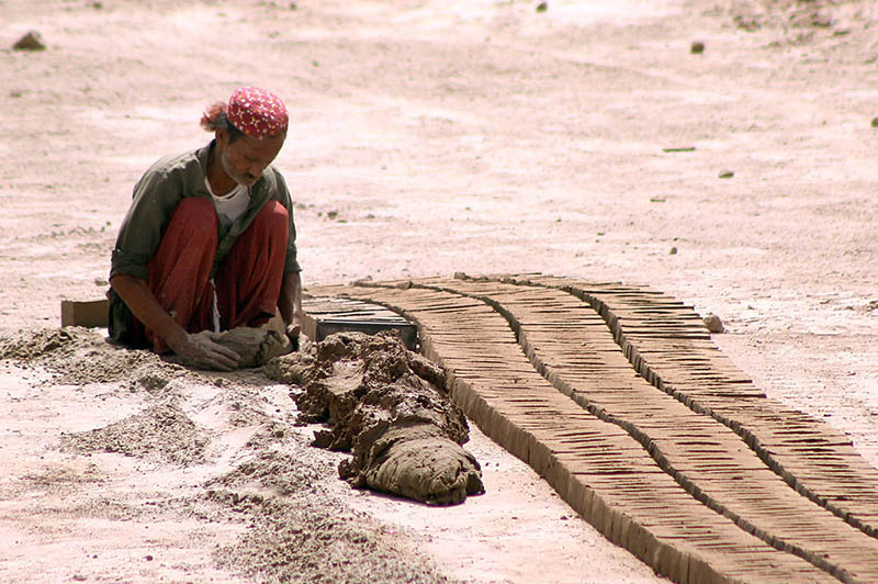 Labourer is busy making raw bricks at a local kiln