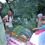 People reciting Holy Quran and offering fateha on the graves of their family members in graveyard on the occasion of Eid ul Azha