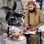 A vendor cleans sacrificial animal trotters (Paya) for customers on the 2nd day of Eid Ul Azha at his workplace