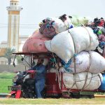 A tri-cycle rickshaw holder on the way loaded with heavy scrap bags at Bypass Road