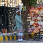 A street vendor displaying traditional household items on his bike