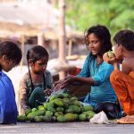 Gypsy children displaying raw mangoes to attract the customers at roadside to earn for livelihood