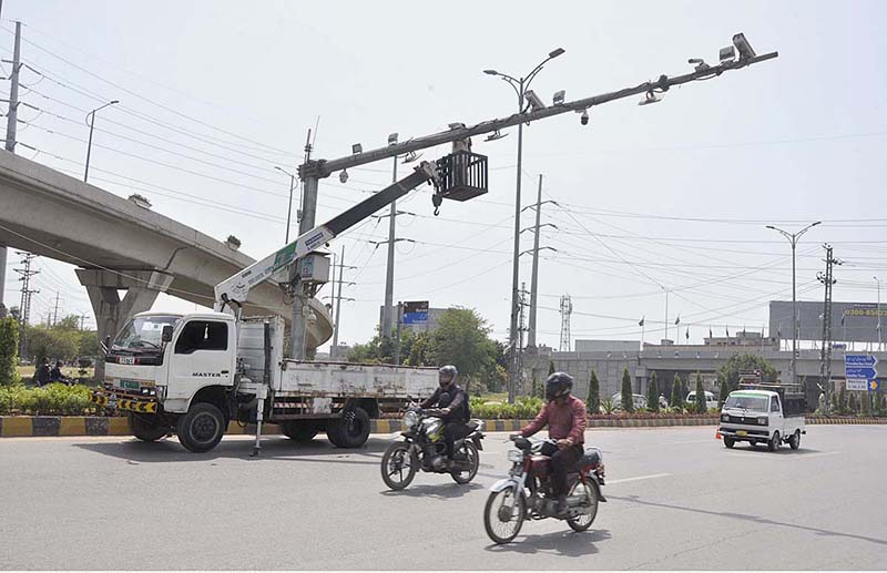 A worker is repairing CCTV cameras during maintenance work in Federal Capital
