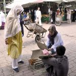Women busy in purchasing handmade fan at H-9 weekly bazar during hot weather in the Federal Capital.