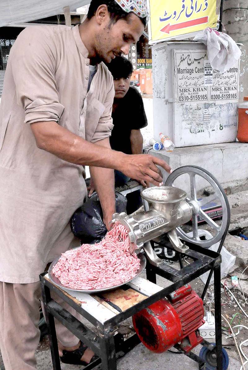 A vendor making mince of sacrificial animal meat for customers on the 2nd day of Eid Ul Azha at his workplace