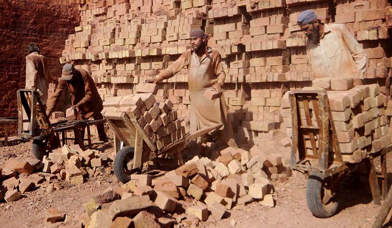 Labourers busy working in local brick kiln during hot weather at outskirts of the Federal Capital