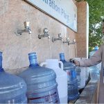 Man filling water bottles from Water Filtering Plant at H-8