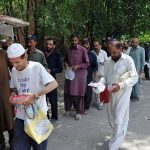 A volunteer distributing free food among deserving people at Mauve Area G-7