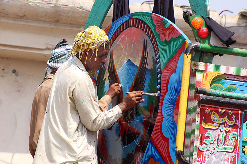 Artisan painting on a delivery truck at Bahawalpur bypass