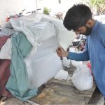 A vendor is cutting ice block into pieces to sell at Rice Canal Road
