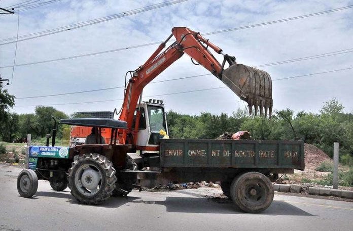 CDA worker removing the sacrificial animal waste from the street on the 2nd day of Eid Ul Azha.