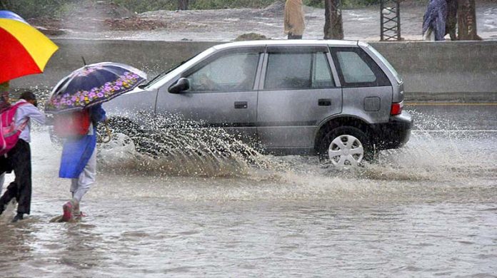 Commuters faces a challenging task of crossing stagnant water amidst heavy rainfall at IJP road
