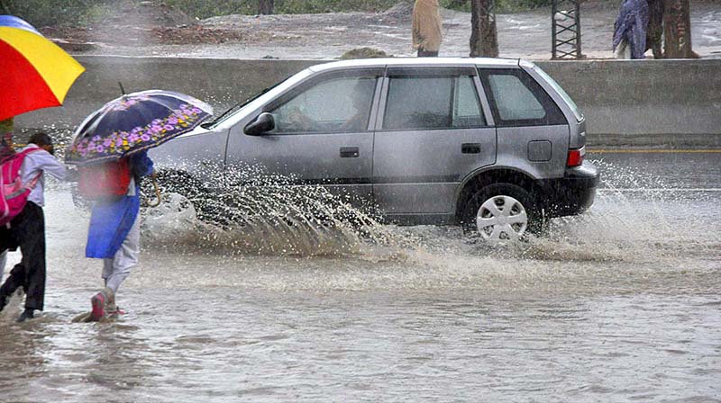 Commuters faces a challenging task of crossing stagnant water amidst heavy rainfall at IJP road