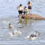 Youngsters swimming to get some relief from hot weather at Rawal Lake spill way stream