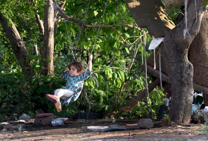 Little girl enjoy swing outside her house at outskirts of the Federal Capital