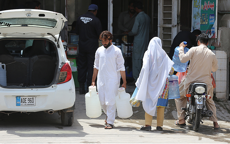 A girl on the way under cover of an umbrella to protect herself from direct sunlight during a hot weather at Ghouri Town