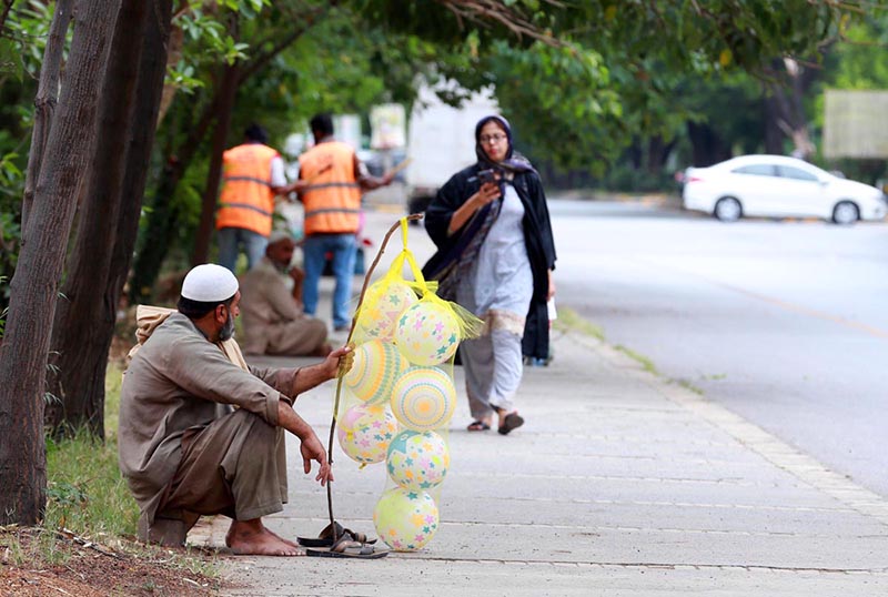 A street vendor displaying balloons to attract customers at Jinnah Super Market