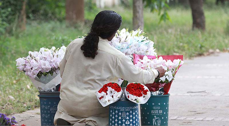 A street vendor displaying flower bouquets to attract customers at Jinnah Super Market