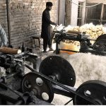 Workers busy producing khas from wood pieces with the help of machine to be used in making of room cooler at his workplace