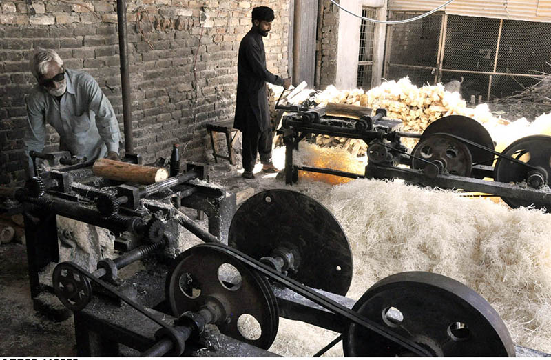 Workers busy producing khas from wood pieces with the help of machine to be used in making of room cooler at his workplace