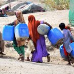 Gypsy children on the way while carrying water canes for filling clean water at Qasimabad