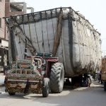 An over loaded tractor trolley parked on busy Millat Road creating hurdles in smooth flow of traffic and needs the attention of concerned authorities
