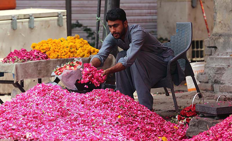 A street vendor displaying flower bouquets to attract customers at Jinnah Super Market