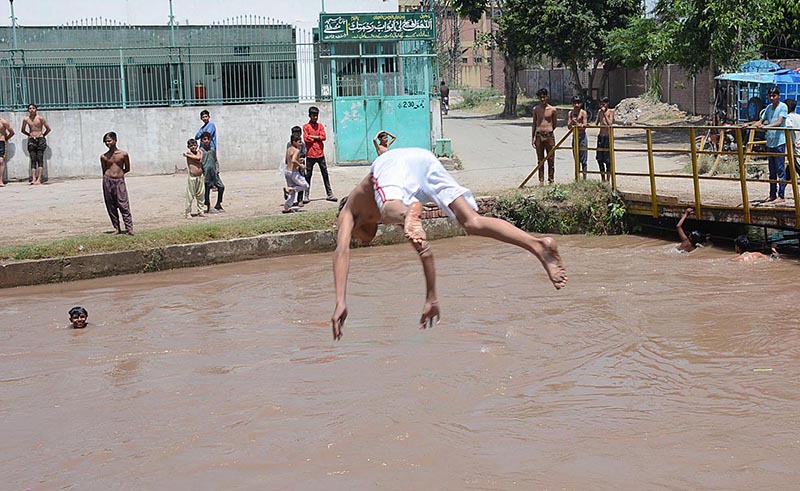 Youngster jumping into the canal to get some relief from hot weather in the city
