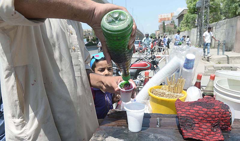 A street vendor preparing traditional sweet stuff known as 'Gola' for a customer at Liaquat Bagh