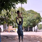 Gypsy children enjoy swings near club Road