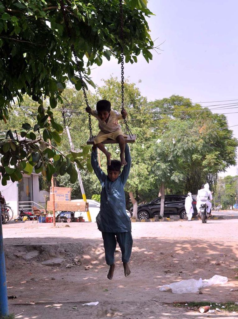 Gypsy children enjoy swings near club Road