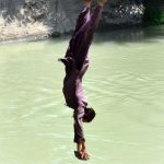 Youngster jumping into the canal to get some relief from hot weather in the city