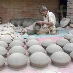 A potter is making traditional clay pots from clay in his workshop at the Kanchi Stop Area