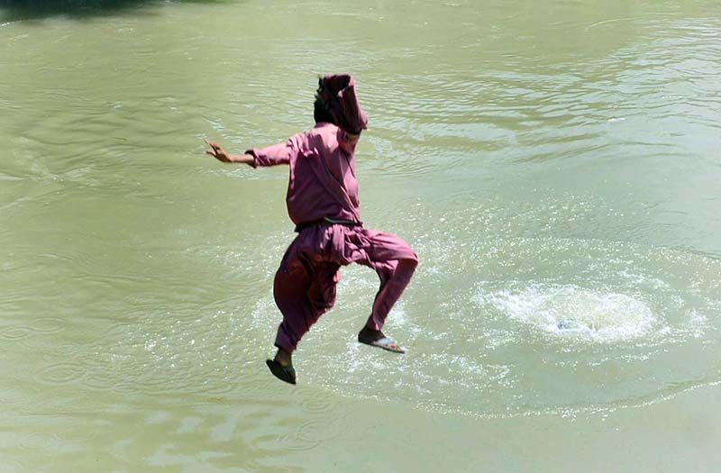 Youngster jumping into the canal to get some relief from hot weather in the city