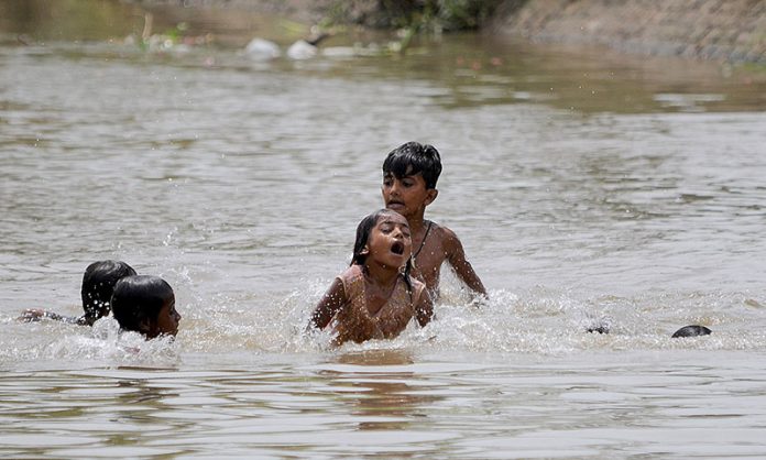 Children are enjoying in the canal to get some relief from the hot and humid weather