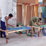 Workers busy in knitting traditional beds (charpai) at their workplace