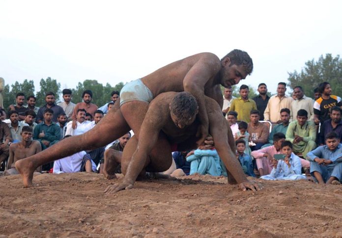 Wrestlers in action during First Begum Kulsoom Nawaz Memorial Fateh Faisalabad Dangal organized by Municipal Corporation at Bohran wali Ground