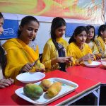 Students eating mangoes during Mango Party at Rail Cambridge School