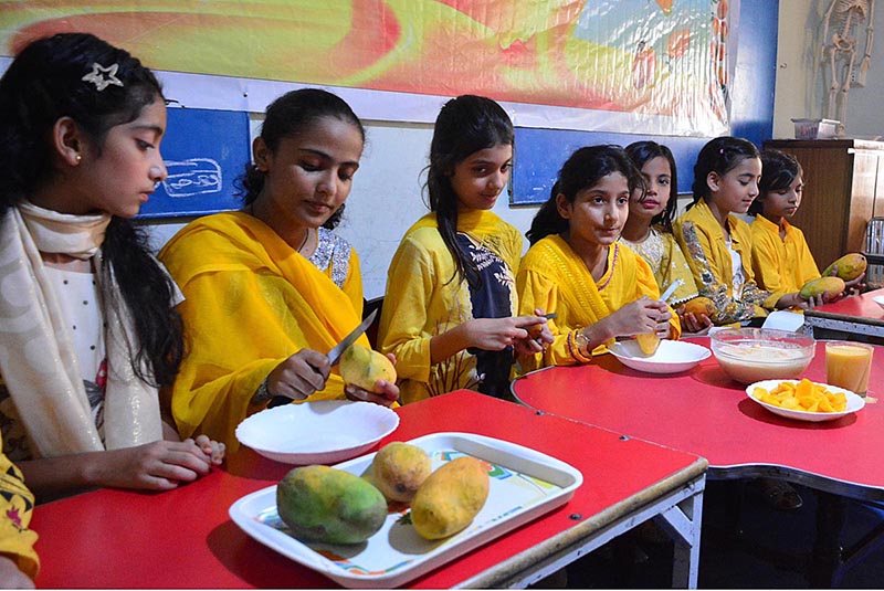 Students eating mangoes during Mango Party at Rail Cambridge School