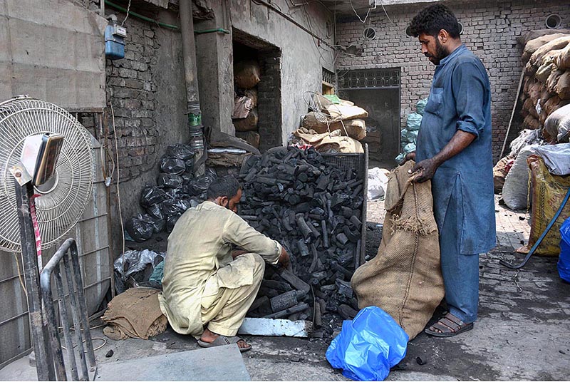 A vendor selling coal to customers as demand increased for upcomming Eid ul-Azha